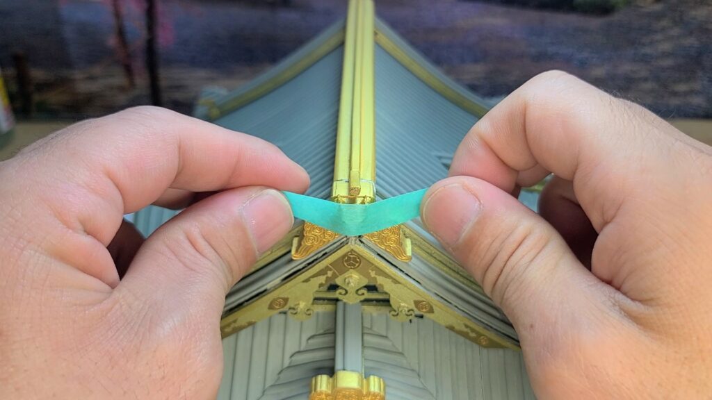 ウッディジョー 日光東照宮陽明門作り方　鬼瓦の鬼面が重いので、ボンドが乾くまで テープで固定