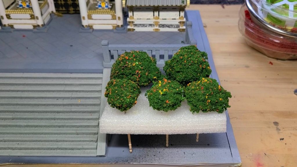 ウッディジョー1/50陽明門の石段脇に白いスポンジを土台にして手作りのさつき5本をバランスよく並べた写真