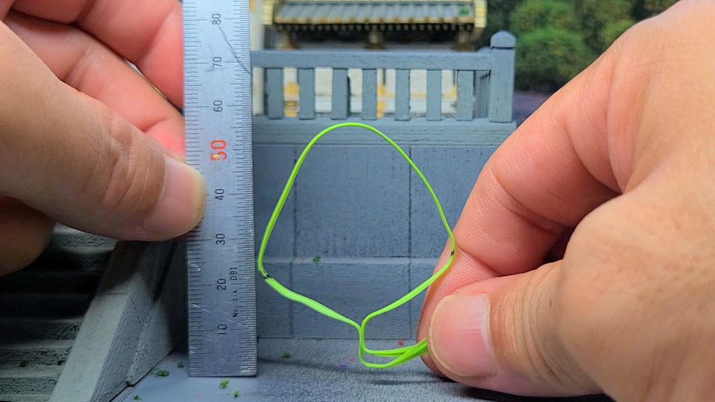 ウッディジョー1/50陽明門の石段の横に大きなビニタイの輪をあてがってサイズを確認